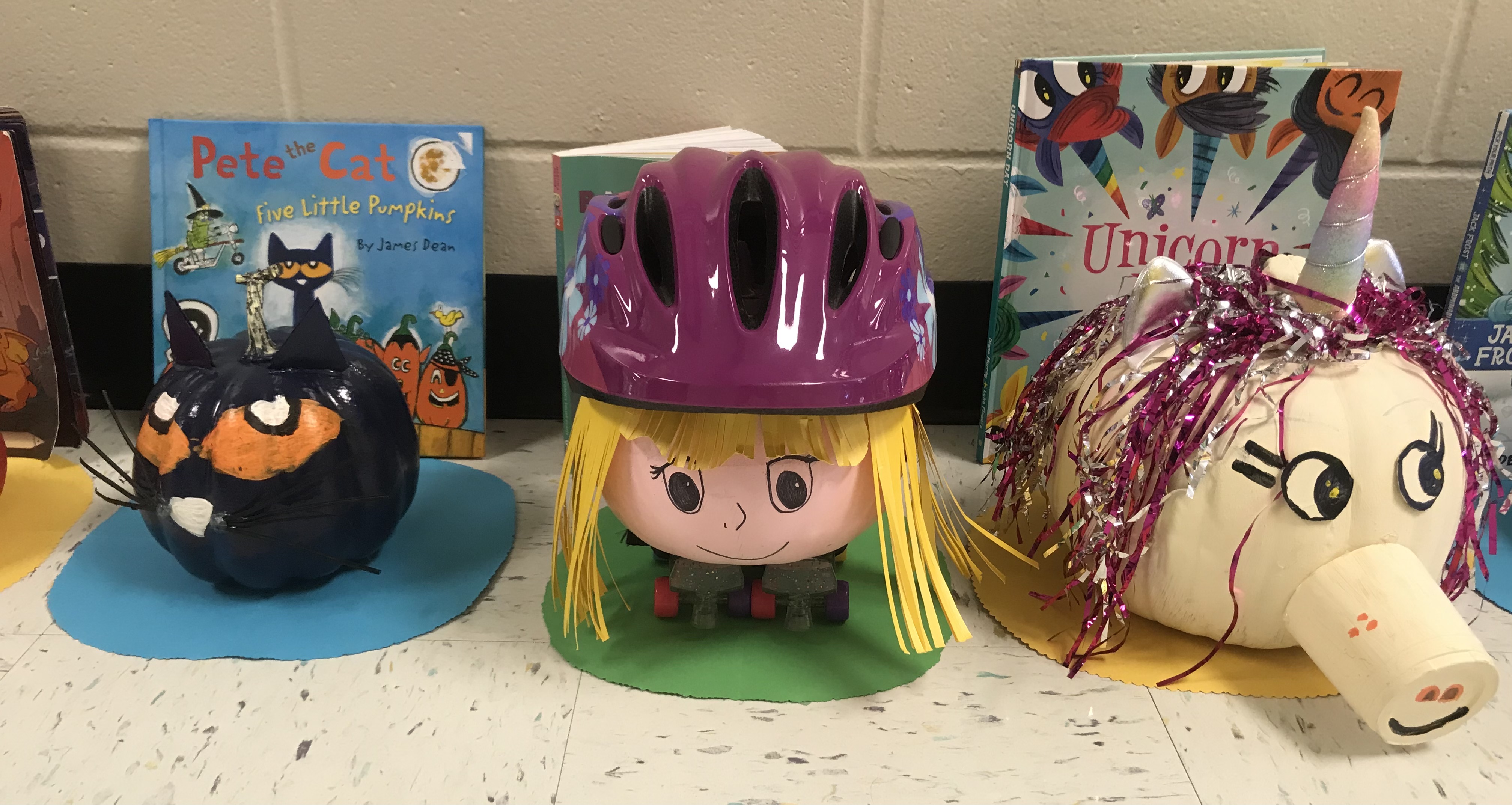 Pumpkins decorated like Pete the Cat, a girl skater and a unicorn
